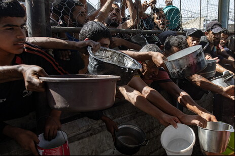 Palestinos em fila de distribuição de comida em Khan Younis, no sul de Gaza